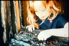 Young girl peeling paint off windsill