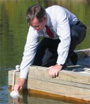 photo of EPA Administrator Mike Leavitt scooping up a water sample