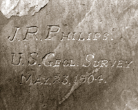 Picture of the inscription skillfully chiseled or engraved into a large boulder of the Permian-aged Coconino Sandstone, which is the third major geologic formation below the Grand Canyon rim.