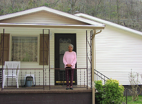 Mrs. Hutton on the porch of her newly repaired home