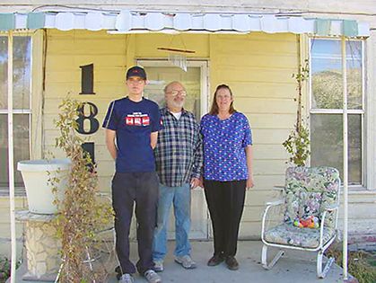 The family in the doorway of their new home.