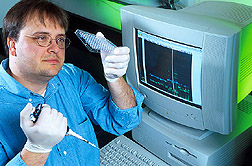 Geneticist prepares to load PCR samples onto an automated DNA sequencer. Link to photo information.