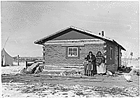 Family in front of house in Wind River Indian Agency in Wyoming
