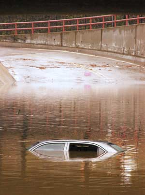 As flood levels subside after heavy rains Oct. 27, a car shows its roof. Behind the swamped car in the foreground are two submerged cars under the Witherby Street subway leading to Marine Corps Recruit Depot San Diego's main entrance. Photo by: Staff Sgt. Scott Dunn