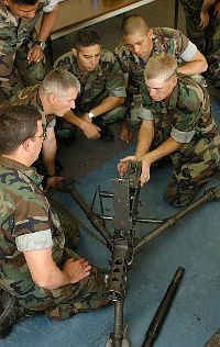 Sailors assigned to Naval Mobile Construction Battalion Two Two (NMCB-22) watch Builder 3rd Class Justin Watkins, right, assemble an M2 M2HB Browning .50 caliber Machine Gun.