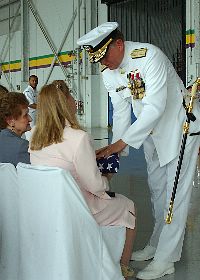 Commander, Naval Air Force Reserve, Rear Adm. Daniel L. Kloeppel, presents his wife and mother with the U.S. Flag at his retirement ceremony.