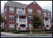 [Photo:  Street view of apartment complex. Silver fire hydrant at street level.]