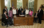 In honor of the 13th anniversary (July 26, 2003) of the Americans with Disabilities Act, President George W. Bush signs the executive order renaming the President's Committee on Mental Retardation to the President's Committee for People with Intellectual Disabilities (PCPID) in the Oval Office Friday, July 25, 2003. In addition to witnessing the signing, the PCPID were on hand to hear President Bush record his weekly radio address. White House photo by Paul Morse