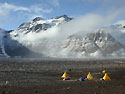 Beacon Valley field camp, located in the Dry Valleys of the Transantarctic Mountains. This research group--part of a Long Term Ecological Research (LTER) Program project--are focusing on the landscape features and soils of Antarctica's Dry Valley region to provide a more complete understanding of past global climatic and environmental conditions.<BR>
<BR>
NSF started the LTER Program in the United States in 1980 as a way to gather broad-based ecological data over a long timescale; the Dry Valleys were added in the early 1990's.  <I>[See related images: Algae Beds at Bottom of Lake Hoare, LTER in Garwood Valley, Don Juan Pond in the Wright Valley.]</I><BR>
<BR>
<U><B>More about this Image</B></U>
The McMurdo Dry Valleys LTER project is an interdisciplinary study of the aquatic and terrestrial ecosystems in a cold desert region of Antarctica. The overall objectives of the McMurdo LTER are to understand the influence of physical and biological constraints on the structure and function of dry valley ecosystems, and to understand the modifying effects of material transport on these ecosystems.<BR>
<BR>
The McMurdo Dry Valleys are located on the western coast of McMurdo Sound (7700'S 16252'E) and form the largest relatively ice-free area (approximately 4800 square kilometers) on the Antarctic continent. The dry valleys are dominated by microorganisms, mosses, and lichens, and higher forms of life are virtually non-existent.<BR>
<BR>
The LTER research in the McMurdo Dry Valleys of Antarctica is very important not just because the area is unique, but because it exists at one end of the arid and cold spectra of terrestrial ecosystems. All ecosystems are dependent upon liquid water and shaped to varying degrees by climate and material transport, but nowhere is this more apparent than in the McMurdo Dry Valleys. In very few places on Earth are there environments where minor changes in climate so dramatically affect the capabilities of organisms to grow and reproduce. Indeed, the data being collected by the LTER indicate that the dry valleys are very sensitive to small variations in solar radiation and temperature and that the site may well be an important natural regional-scale laboratory for studying responses to human alterations of climate. While the Antarctic ice sheets respond to climate change on the order of thousands of years, the glaciers, streams, and ice-covered lakes in the McMurdo Dry Valleys respond to change almost immediately. Thus, it is in the McMurdo Dry Valleys that the first effects of climate change in Antarctica should be observed.<BR>
<BR>
The McMurdo Dry Valleys LTER project has successfully completed eight field seasons (October-February) since 1993. During the 1993-94 season 18 scientists were deployed to McMurdo Station and Taylor Valley to conduct research associated with the LTER project. These scientists initiated core measurement programs to obtain baseline ecologically relevant data from the atmosphere, glaciers, streams, soils, and lakes. Since then, about 25 scientists each season have participated.  Thumbnail