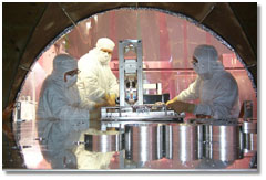 LIGO scientists make adjustments to a mirror; caption is below