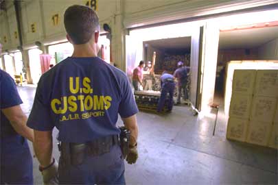 Customs Inspectors photo by James R. Tourtellotte A U.S. Customs Inspector at the Long Beach California Sea Port watches as a team unloads agricultural products from a truck making certain that no contraband is on board. http://www.customs.gov/xp/cgov/newsroom/image_library/afc/customs_tracters/ci_11.xml