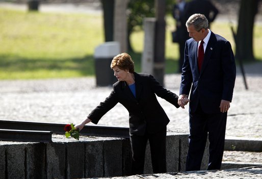 President George W. Bush and Mrs. Bush place a rose at the end of the railroad tracks at the Birkenau concentration camp in Poland, Saturday, May 31, 2003. White House photo by Paul Morse.