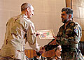 U.S. Air Force Maj. Gen. Craig Weston, chief of the Office of Military Cooperation - Afghanistan, awards a graduation certificate to one of the graduates at the ceremony. U.S. Army photo by Master Sgt. D. Keith Johnson