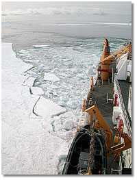 hunks of broken ice float along the icebreaker's hull