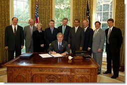 President George W. Bush signs S. 342, the Keeping Children and Families Safe Act of 2003, in the Oval Office Wednesday, June 25, 2003. The act reauthorizes the Child Abuse Prevention and Treatment Program and other related programs. White House photo by Susan Sterner.