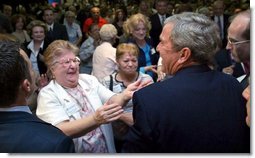 President George W. Bush reacts to a kiss by a senior citizen after speaking about pending Medicare legislation at the Little Havana Activities and Nutrition Center in Miami, Fla., June 30, 2003. White House photo by Paul Morse.