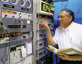 NIST physicist Judah Levine pushes a button on the control panel  for NIST Time & Frequency Services.
