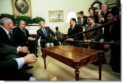 President George W. Bush talks with the press during an Oval Office meeting with several Iraqis who receive medical care in the United States Tuesday, May 25, 2004. "I'm honored to shake the hand of a brave Iraqi citizen who had his hand cut off by Saddam Hussein," said the President. "I'm with six other Iraqi citizens, as well, who suffered the same fate. They are examples of the brutality of the tyrant." White House photo by Eric Draper.