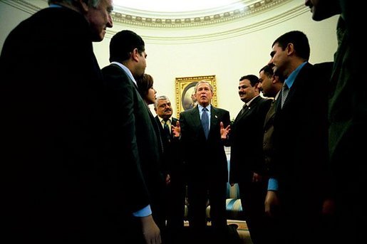 President George W. Bush talks with several Iraqis who receive medical care in the United States during a meeting in the Oval Office Tuesday, May 25, 2004. The Iraqi citizens each had one hand cut off in Iraq during Saddam's rule. "They are examples of the brutality of the tyrant," said President Bush. "These men had hands restored because of the generosity and love of an American citizen. And I am so proud to welcome them to the Oval Office." White House photo by Eric Draper.