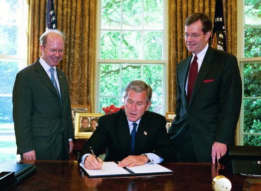 President George W. Bush signs the executive order establishing his Great Lakes Interagency Task Force, with EPA Administrator Michael Leavitt and James Connaughton, chairman of the Council on Environmental Quality, in the Oval Office Tuesday, May 18, 2004. The task force brings together ten agency and Cabinet officers to provide strategic direction on Federal Great Lakes policy, priorities and programs. White House photo by Paul Morse.