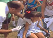 Foto de un empleado de la salud vacunando una niña