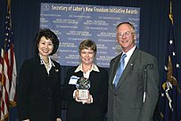 Secretary of Labor Elaine L. Chao (L) and Assistant Secretary of Labor for Disability Employment Policy Roy Grizzard (R) present a 2003 Secretary of Labors New Freedom Initiative Award to Salisbury Chamber of Commerce