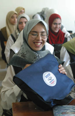 A student from the Hala Bint Khuwaylid secondary girl's school in the Amil district of Baghdad with her new school bag which contains, pens, pencils, notebooks, a  a calculator and other school supplies. USAID is funding the purchase and distribution of 1.5 million of the bags through a contract with Creative Associates International. All Iraqi secondary students will receive the bags.