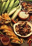 An array of foods including corn, tacos, and fajitas.