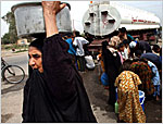 A resident balances a tub filled with water on her head after filling it from a tanker truck in Basra on April 22.