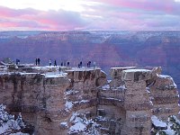 VISITORS AT SUNSET VIEWING THE GRAND CANYON  FROM MATHER POINT ON THE SOUTH RIM AFTER A DUSTING OF WINTER SNOW.