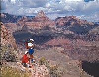 DAYHIKERS PAUSE TO VIEW THE CANYON ON THE GRANDVIEW TRAIL. THE POINTED PEAK, BEHIND THEM IS VISHNU TEMPLE.