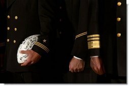 Signed by the entire team as a gift for the President, a football is tucked under the arm of a member of the U.S. Naval Academy football team during the presentation of the Commander-In-Chief Trophy in the East Room Monday, April 19, 2004. White House photo by Tina Hager.
