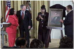 Proclaiming a holiday in honor of Martin Luther King, Jr., President George W. Bush receives a portrait of the civil rights leader from his wife and children in the East Room Jan. 21, 2002. Photographed from left to right are Coretta Scott King, the President, Rev. Bernice King and Martin Luther King III. WHITE HOUSE PHOTO BY TINA HAGER.