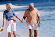 an older couple walking on the beach
