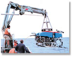 Research scientists lowering the deep sea explorer