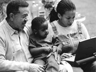 Photo of a grandfather, daughter, and grandson sitting on a park bench