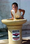A boy drinks from a water fountain provided by USAID