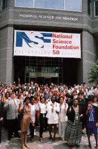 Staff in front of building and 50th Anniversary banner