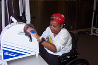 Photo of an African American woman using an arm ergometer.