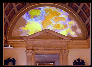 The Einstein's Dilemma exhibit featuring splashes of color projected onto an archway within the Caltech Athenaeum.