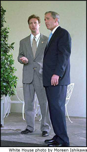President George W. Bush talks with Dr. Richard Tubb, Col. USAF, Director, White House Medical Unit, along the West Wing Colonnade June 25, 2001.