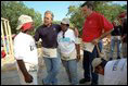 President Bush and Secretary for Housing and Urban Development Martinez, right, talk with new friends during a break from their house-building efforts at the Waco, Texas, location of Habitat for Humanity's "World Leaders Build" construction drive August 8, 2001. 