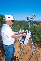 Photo: Schmugge sets up a thermal instrument to measure temperature on the Jornada Range. Link to photo information
